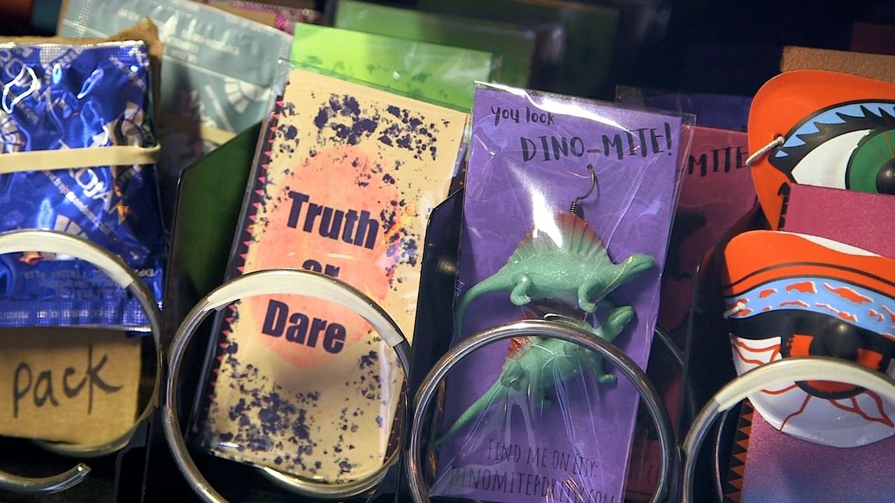 Truth or Dare cards and dinosaur earrings  sit loaded in a vending machine.